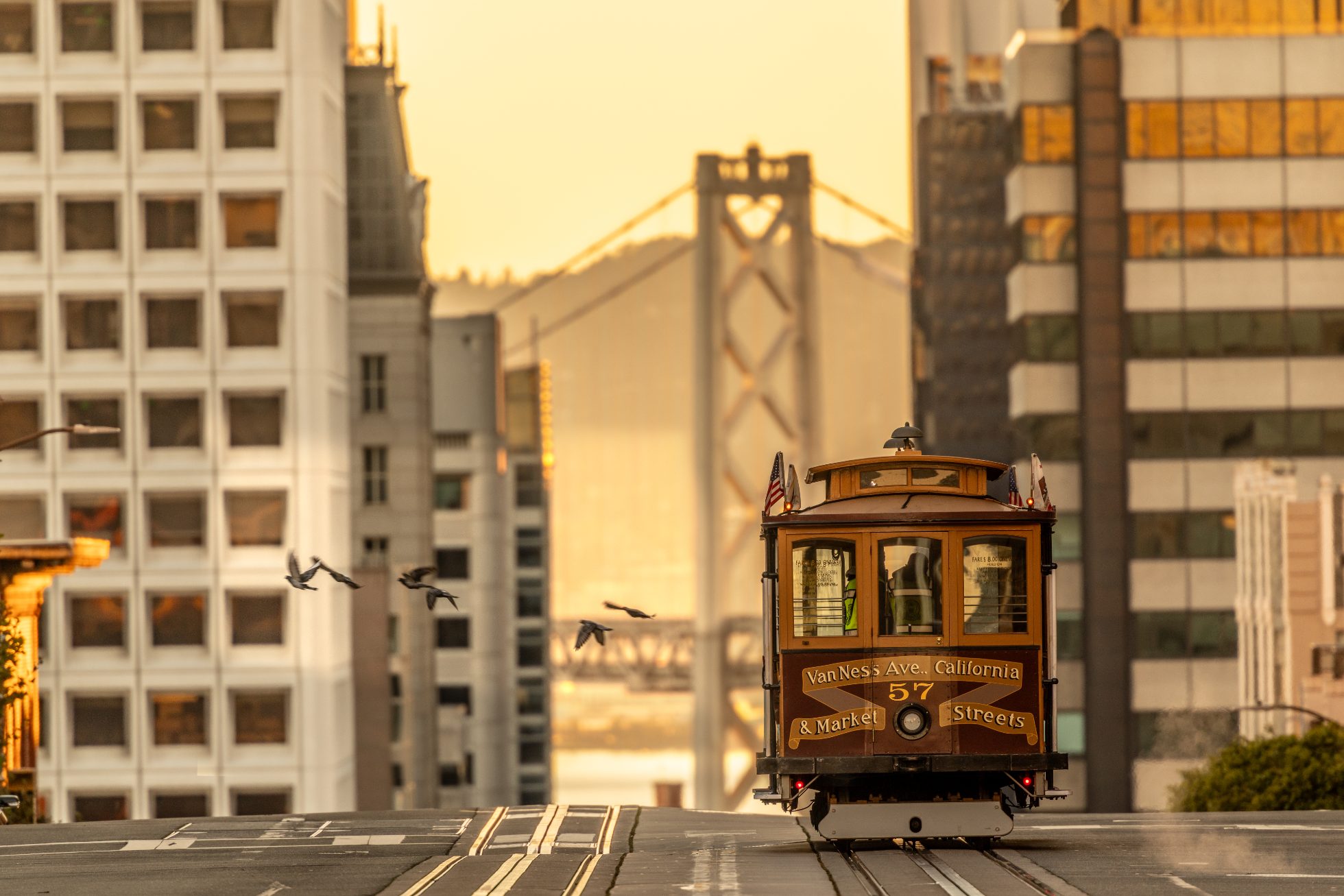 Widok ze szczytu Nob Hill na wschód, w kierunku wieży mostu Bay Bridge, z tramwajem linowym San Francisco Van Ness o świcie.
